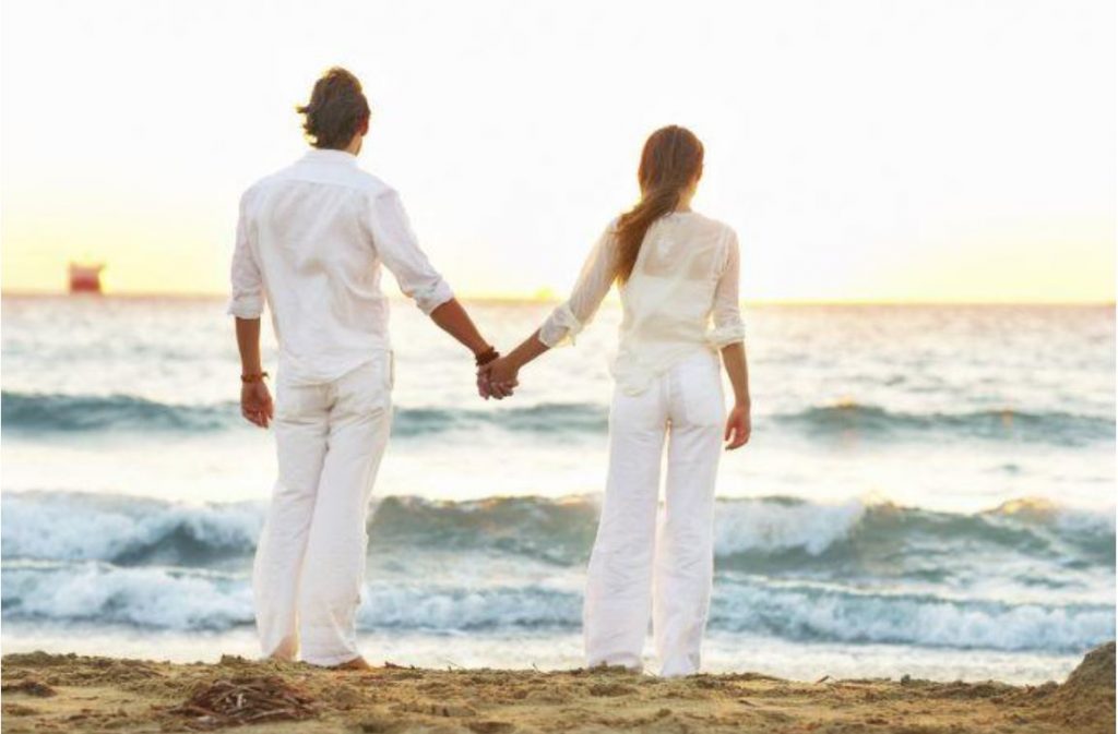 couple holding hands beach